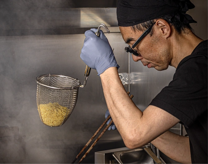 Our chef draining freshly boiled noodles
